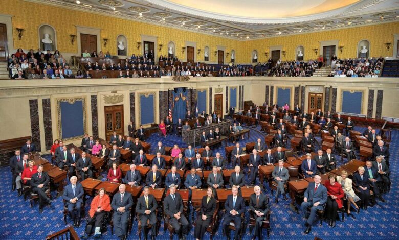 A wide view of the United States Senate chamber with senators and staff seated at desks, visitors in the galleries, and the chamber’s blue-and-gold decor, dais, and U.S. flag visible.