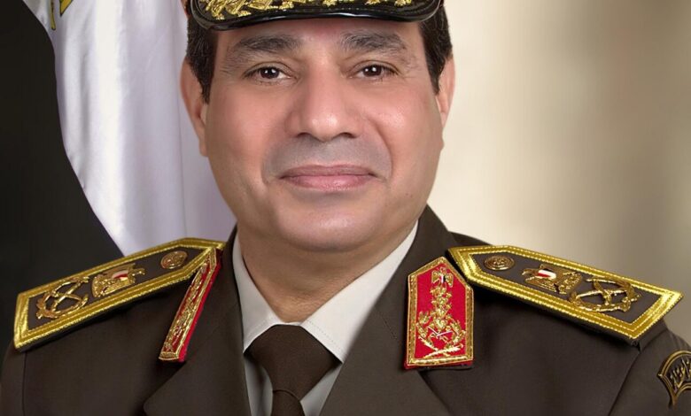 A uniformed Egyptian military officer poses for a head-and-shoulders portrait against a neutral backdrop, wearing a peaked cap and a dress uniform with medals and ribbons.